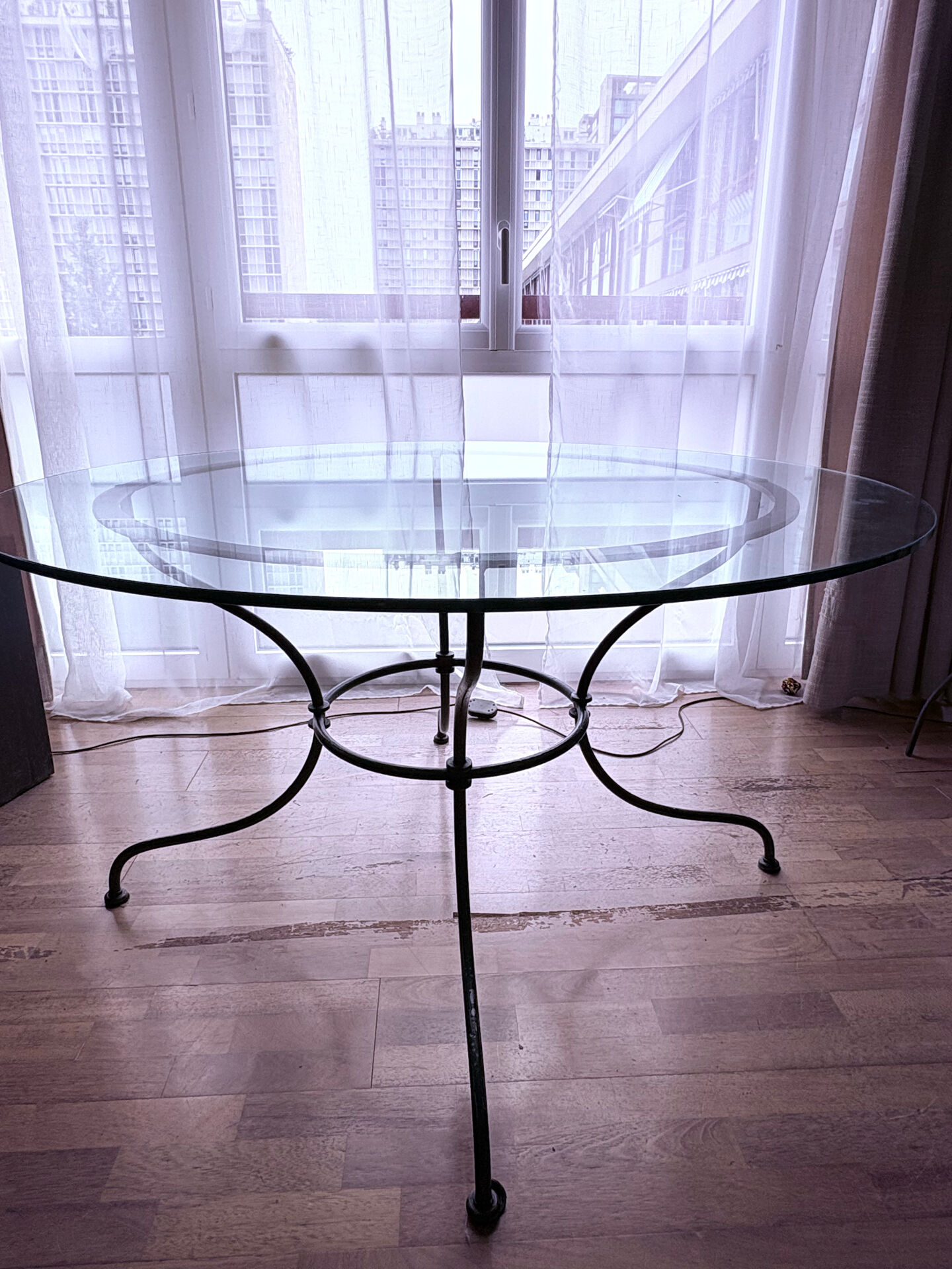 Round dining table in glass and wrought iron.