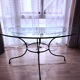 Round dining table in glass and wrought iron.
