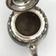 Old teapot pourer in silver metal decorated with foliage and butterflies