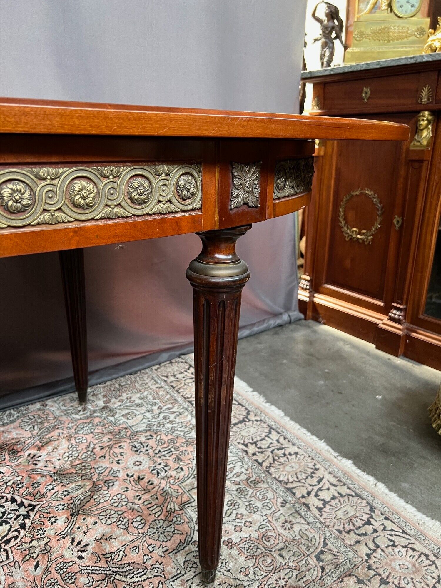 Louis XVI style oval dining table with rosewood marquetry extension mounted in bronze