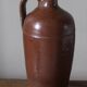 Vintage stoneware liqueur bottle with handle and spout.