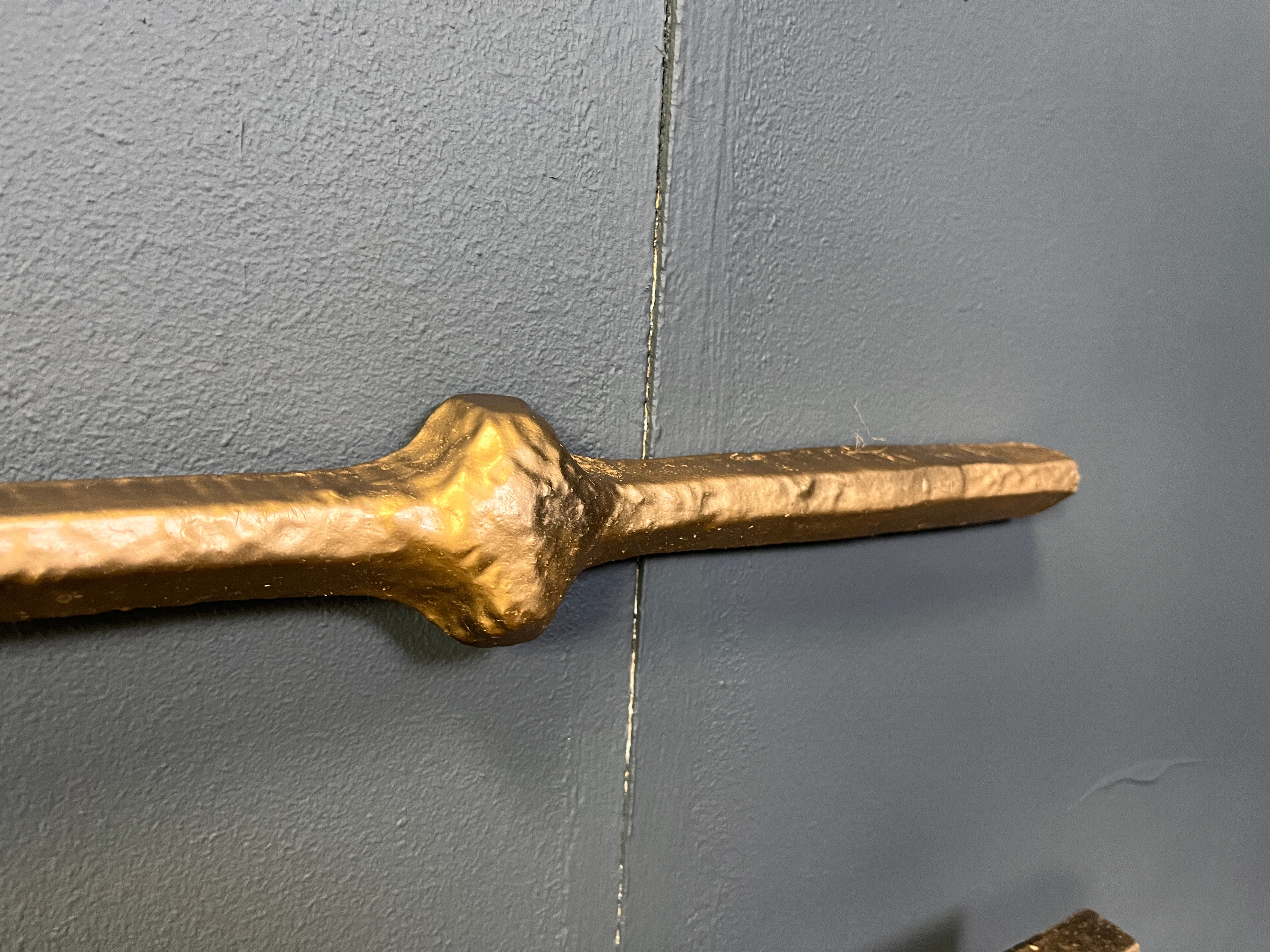 Architectural brutalist wall mounted sculpture made from cast metal.