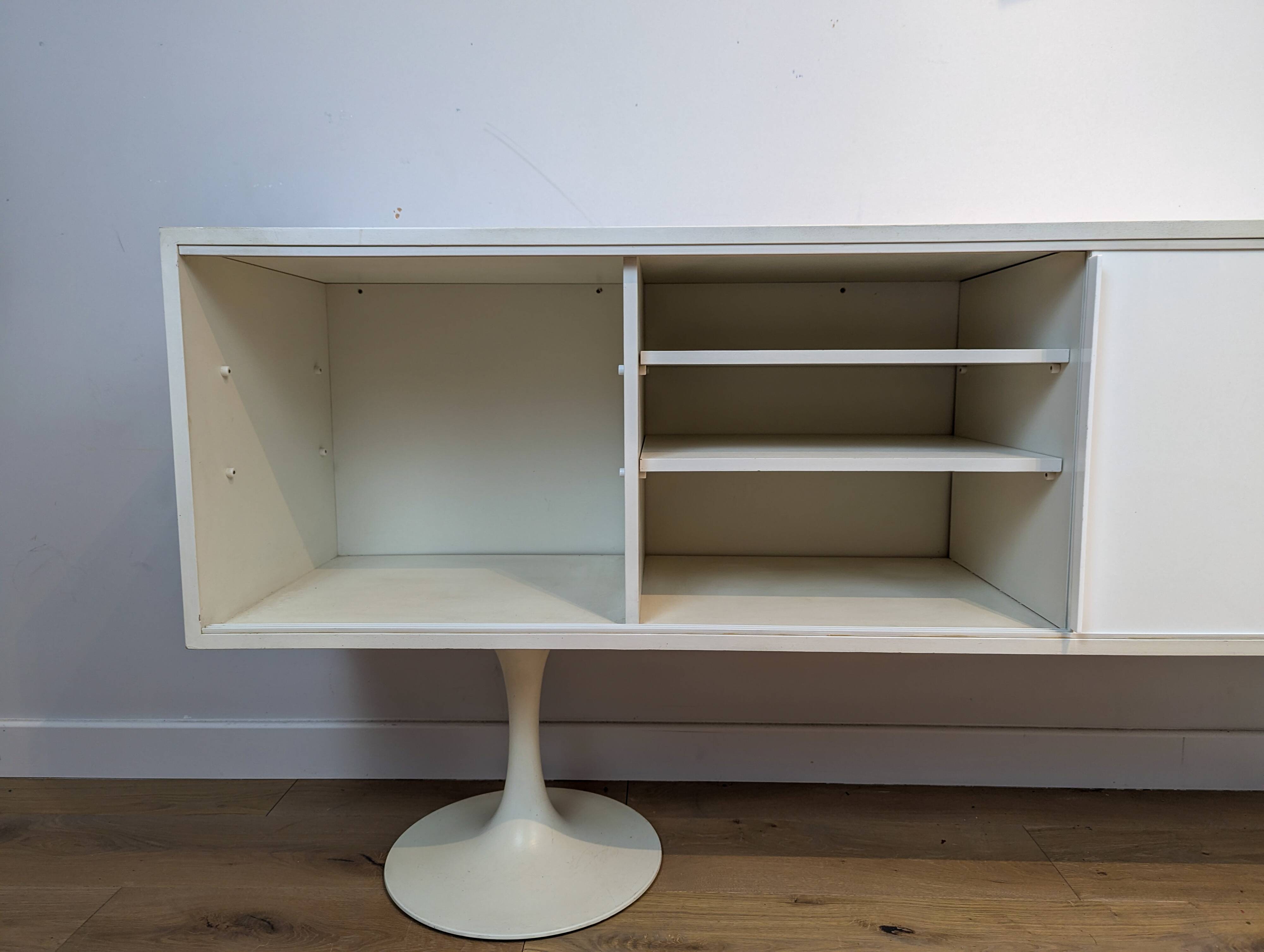A vintage mid century space age sideboard with white sliding doors