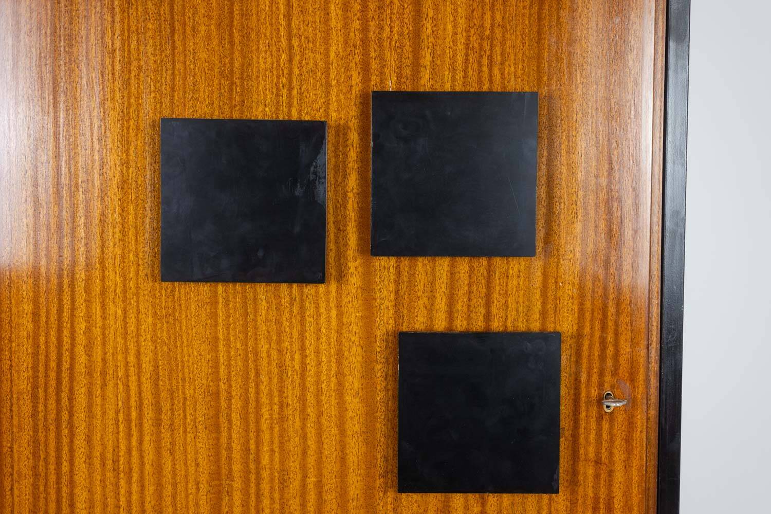 Pair of mahogany veneer and black lacquered iron cabinets. 1950s.