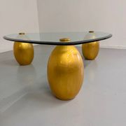 Vintage Italian design coffee table with a glass top and gold base, dating from the 1980s.