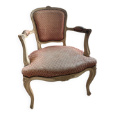 Fauteuil cabriolet de style Louis XV en bois patiné, tapissé d’un élég