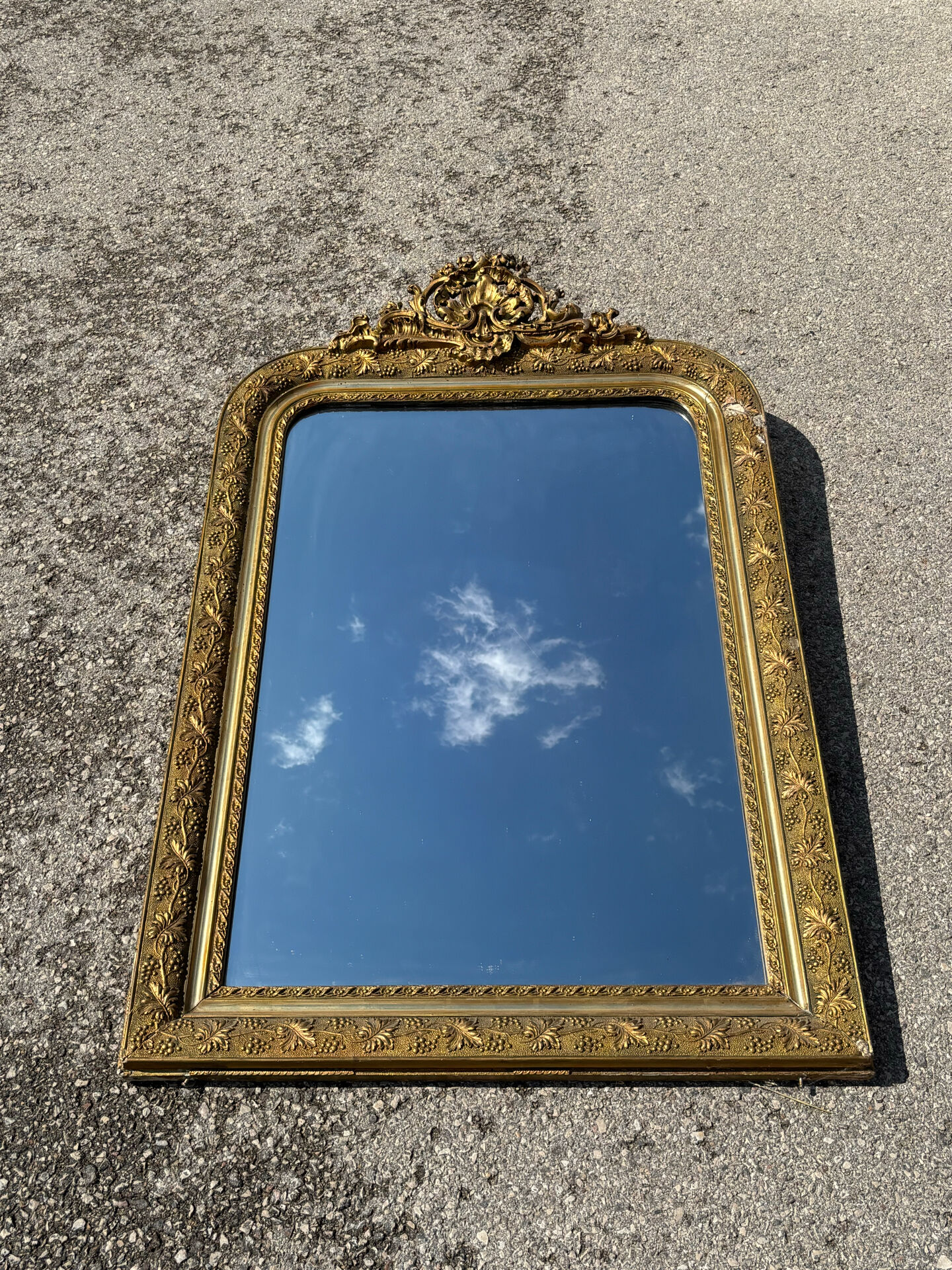 Golden mirror with a pediment from the early 20th century.