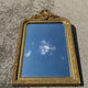 Golden mirror with a pediment from the early 20th century.