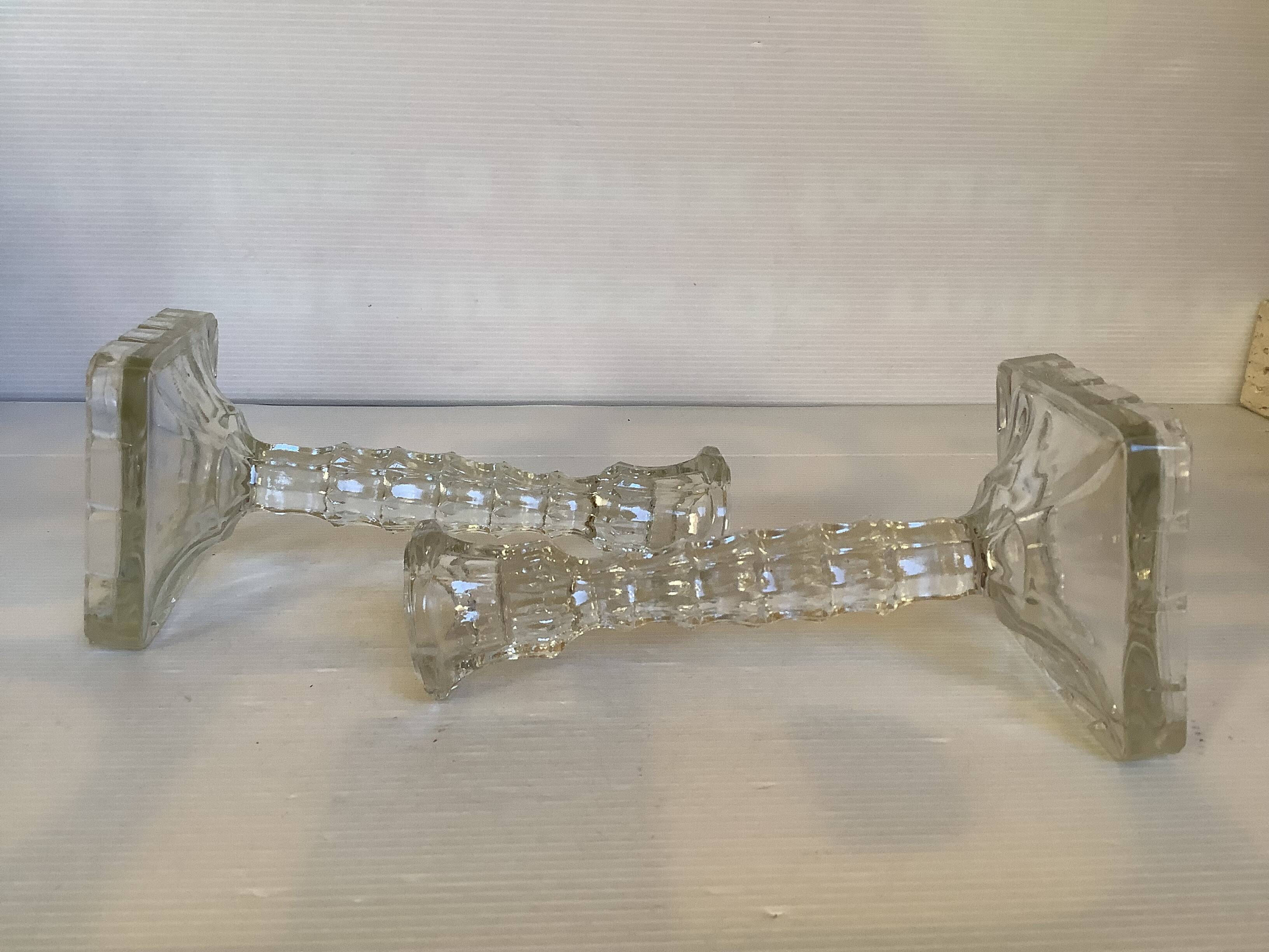 Pair of tall candle holders in the shape of a flower with a square base.