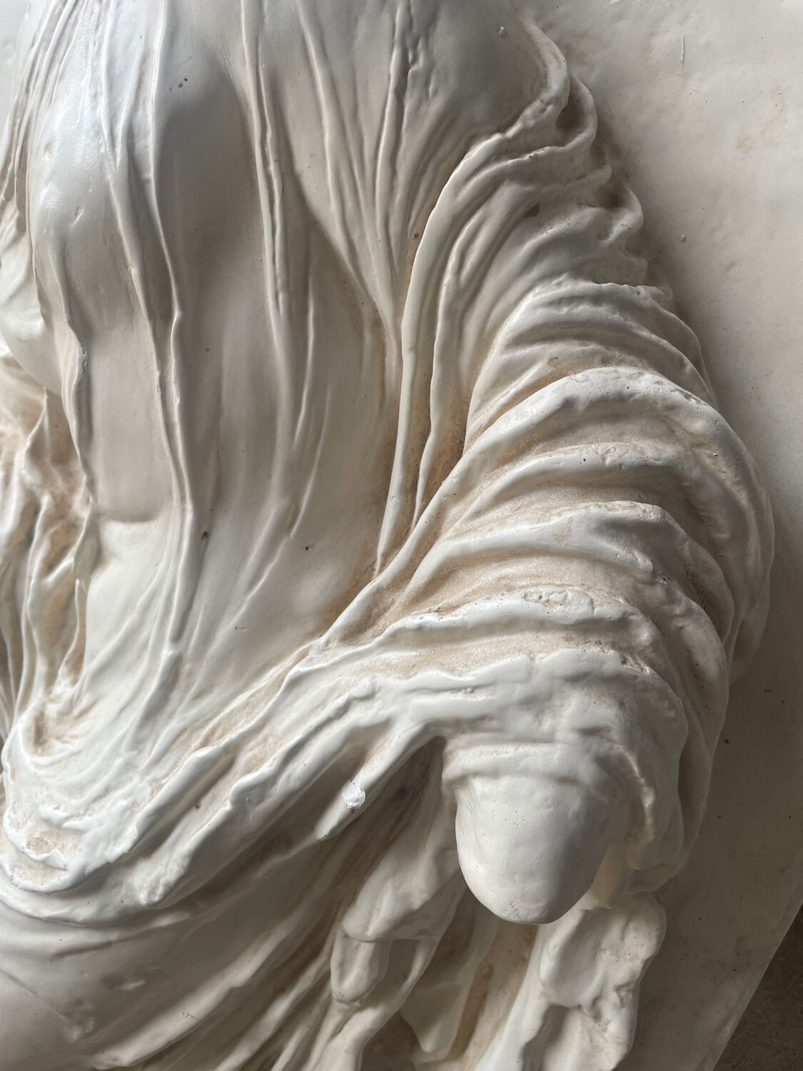 Ancient plaster bas-relief of Nike fastening her sandal.