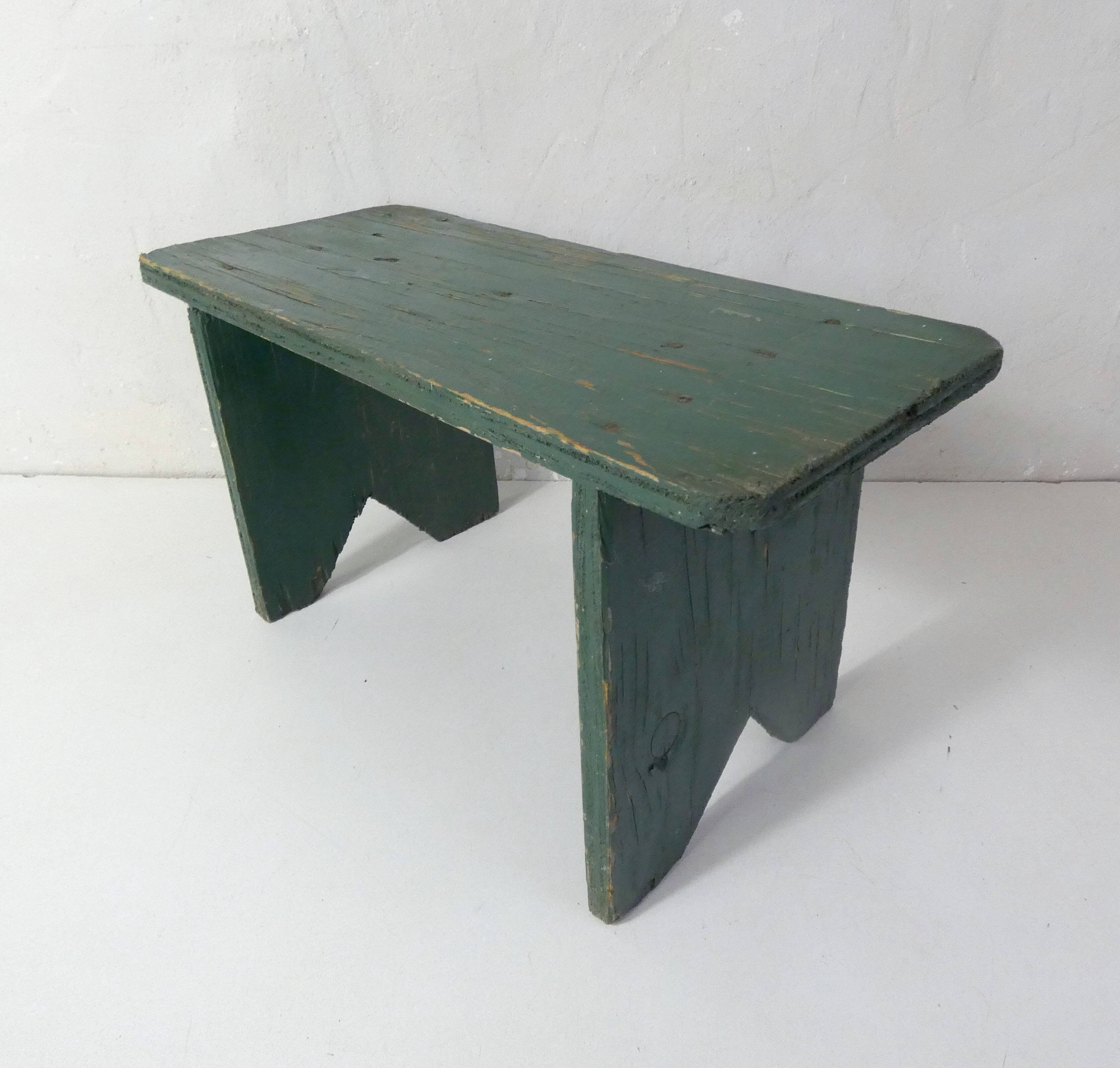 Old small wooden bench with green foot
