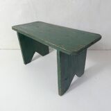 Old small wooden bench with green foot