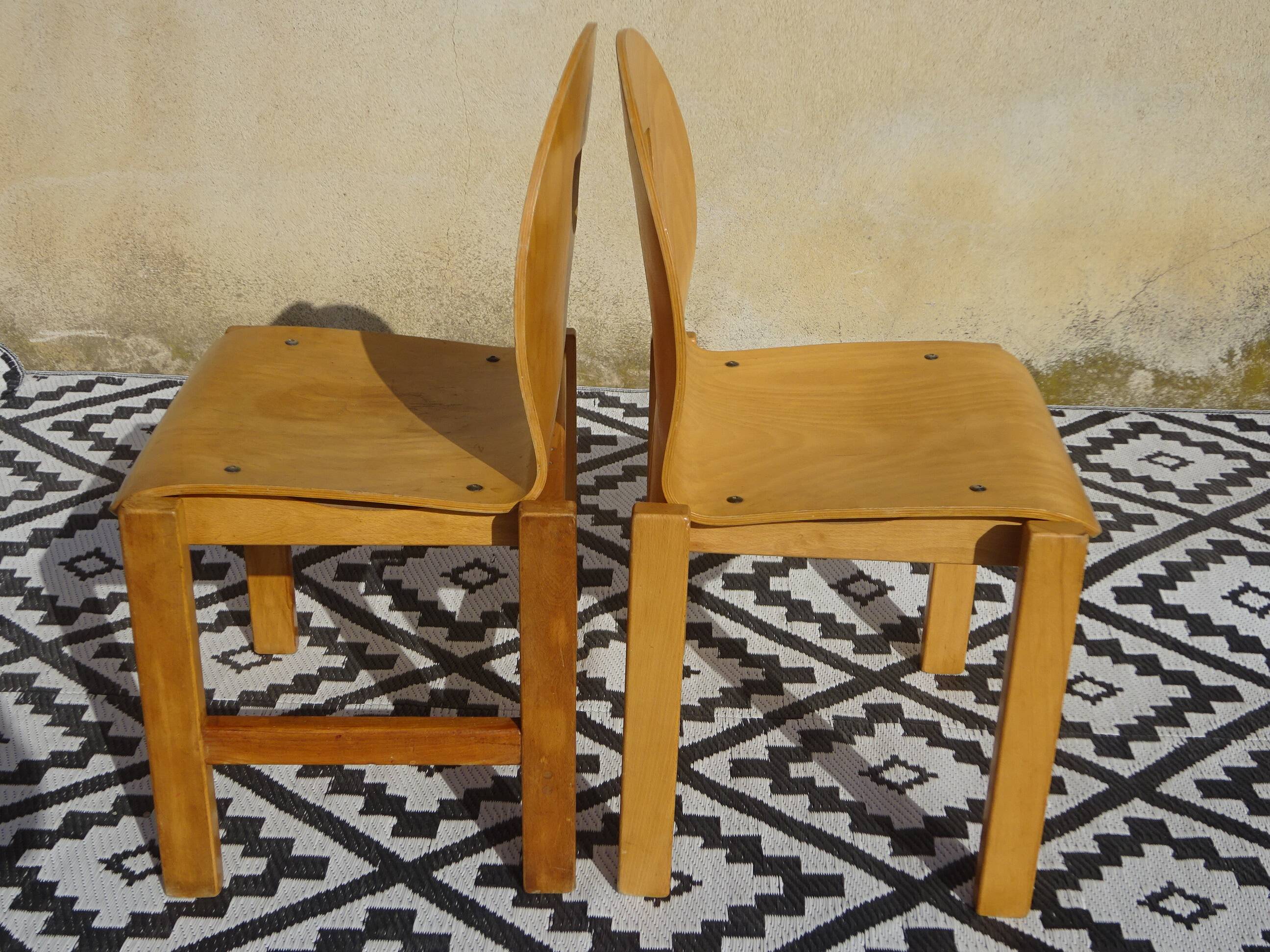 Pair of light wood chairs with post-formed seat and backrest.