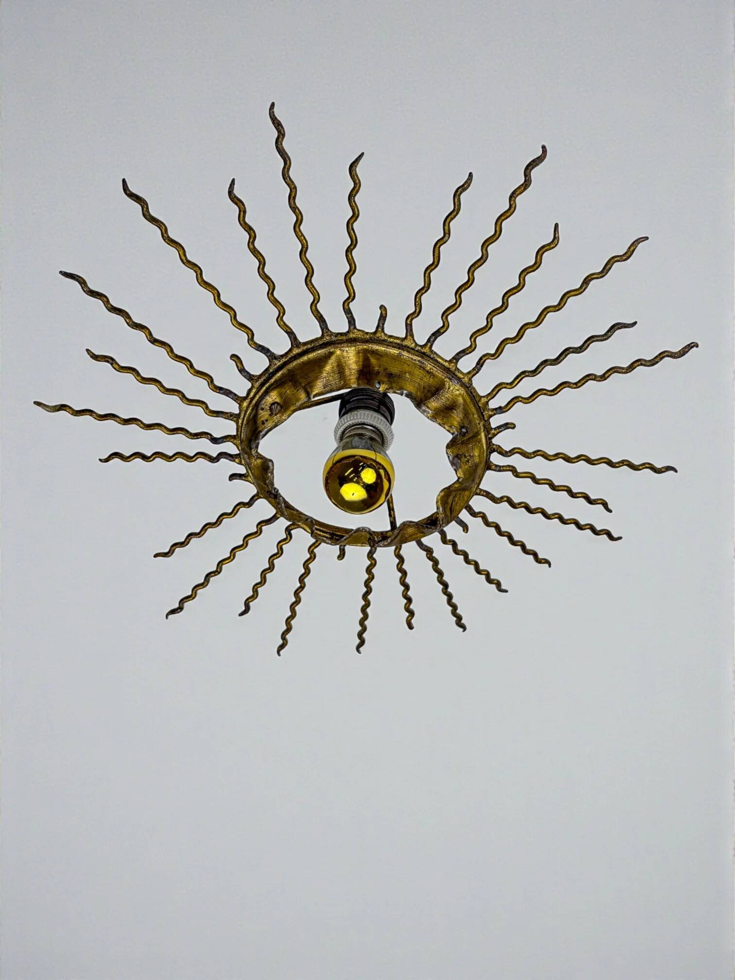 Spanish sunburst ceiling light – gilt iron rays & exposed bulb, 1960s