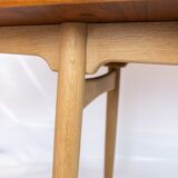Dining table in teak and oak with extensions designed by Hans J. Wegner