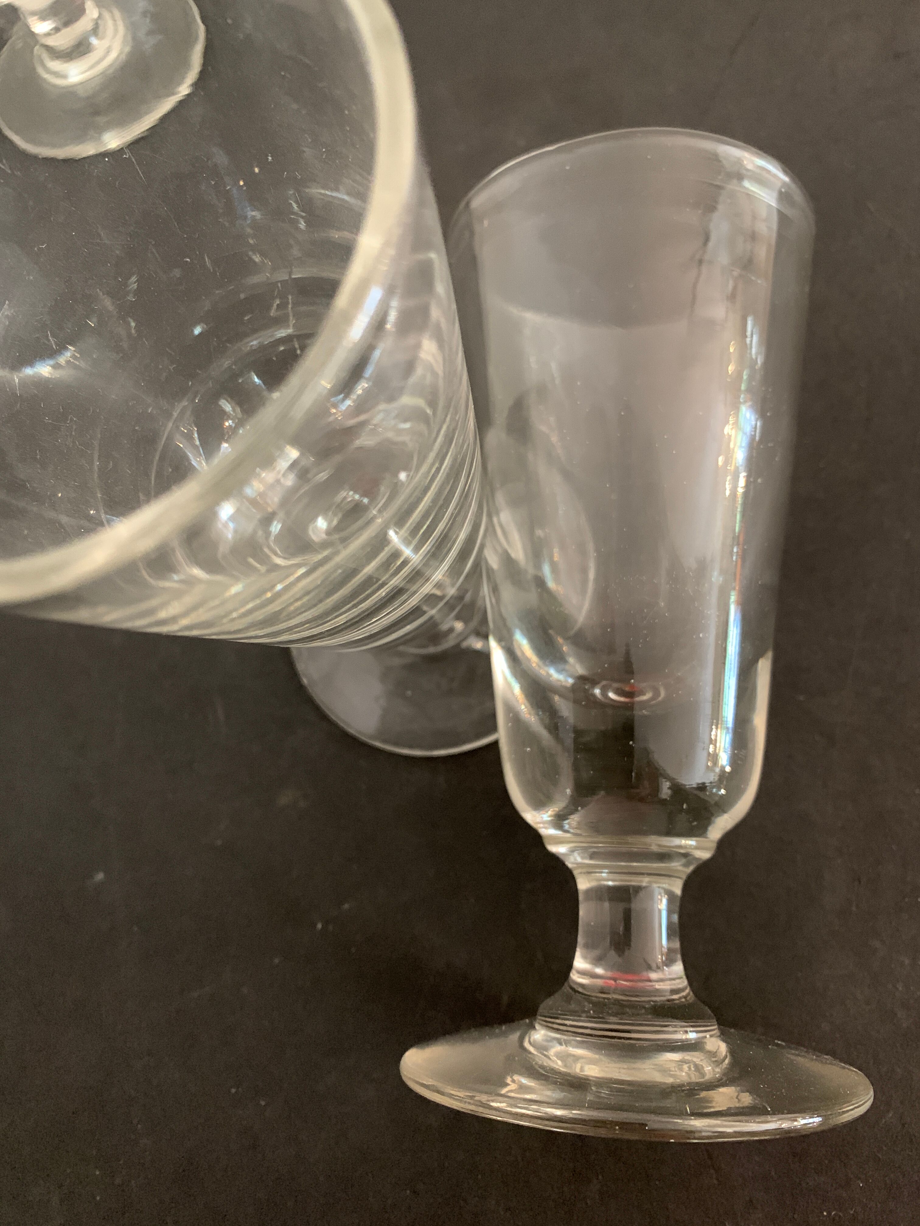 12 old glasses on foot at bistro or absinthe