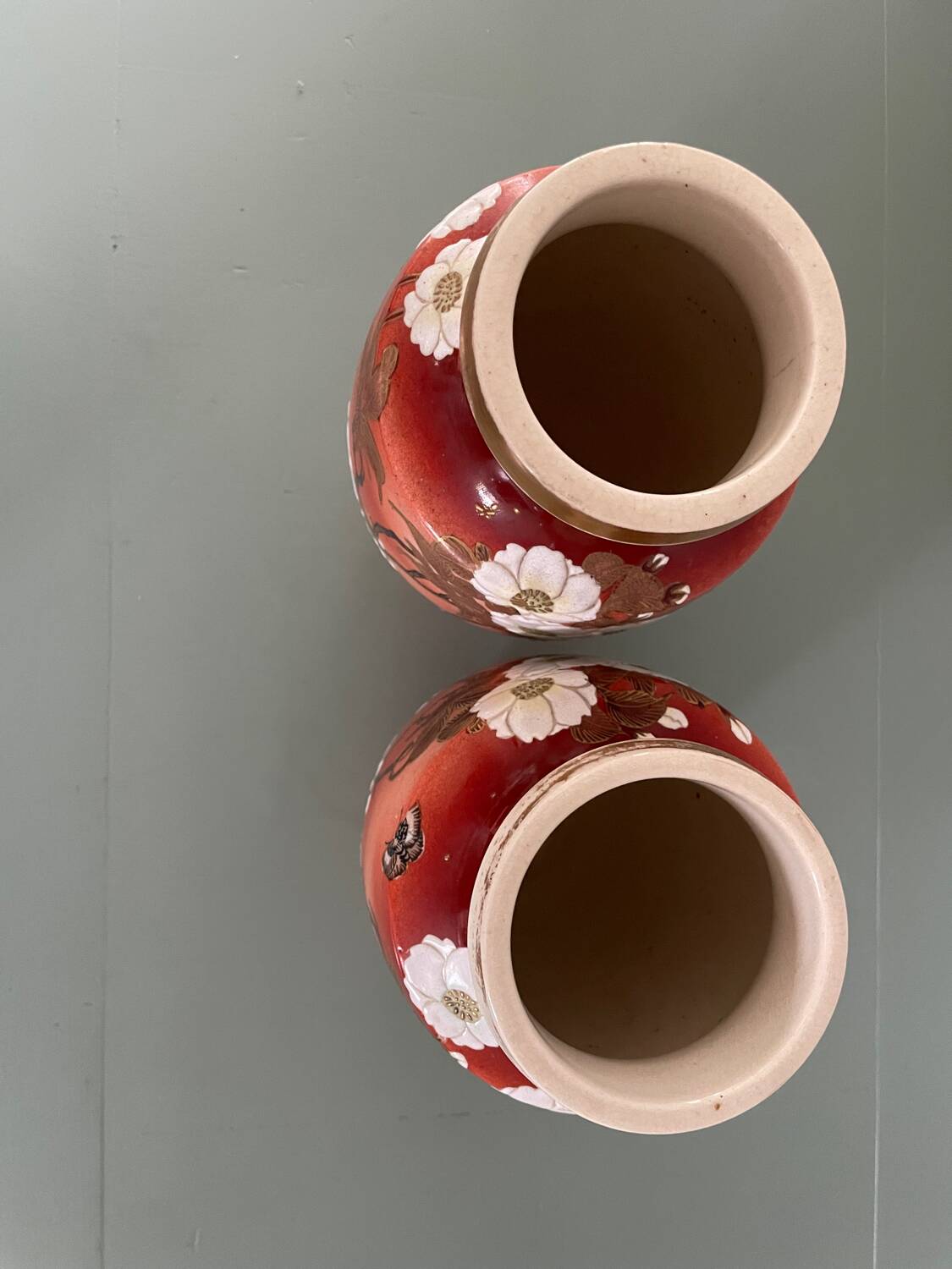 Pair of antique vases with butterfly and flower motif.