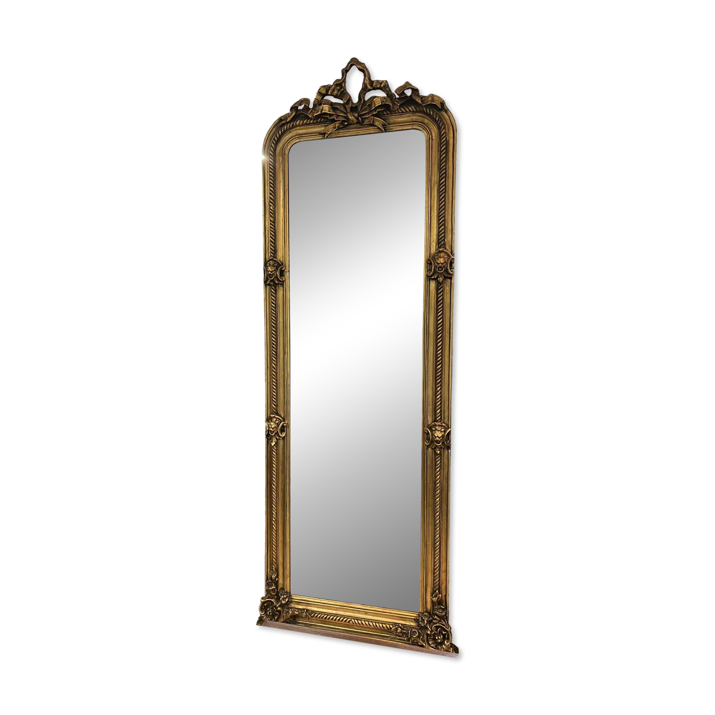 French palace mirror with bow and lion heads, gilded frame.