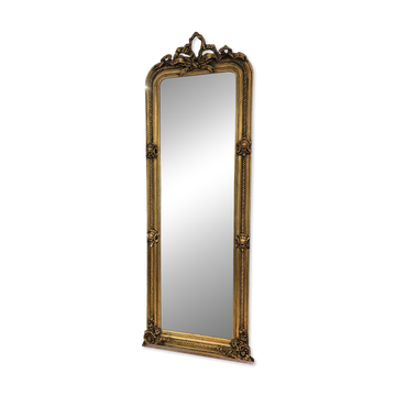 French palace mirror with bow and lion heads, gilded frame.