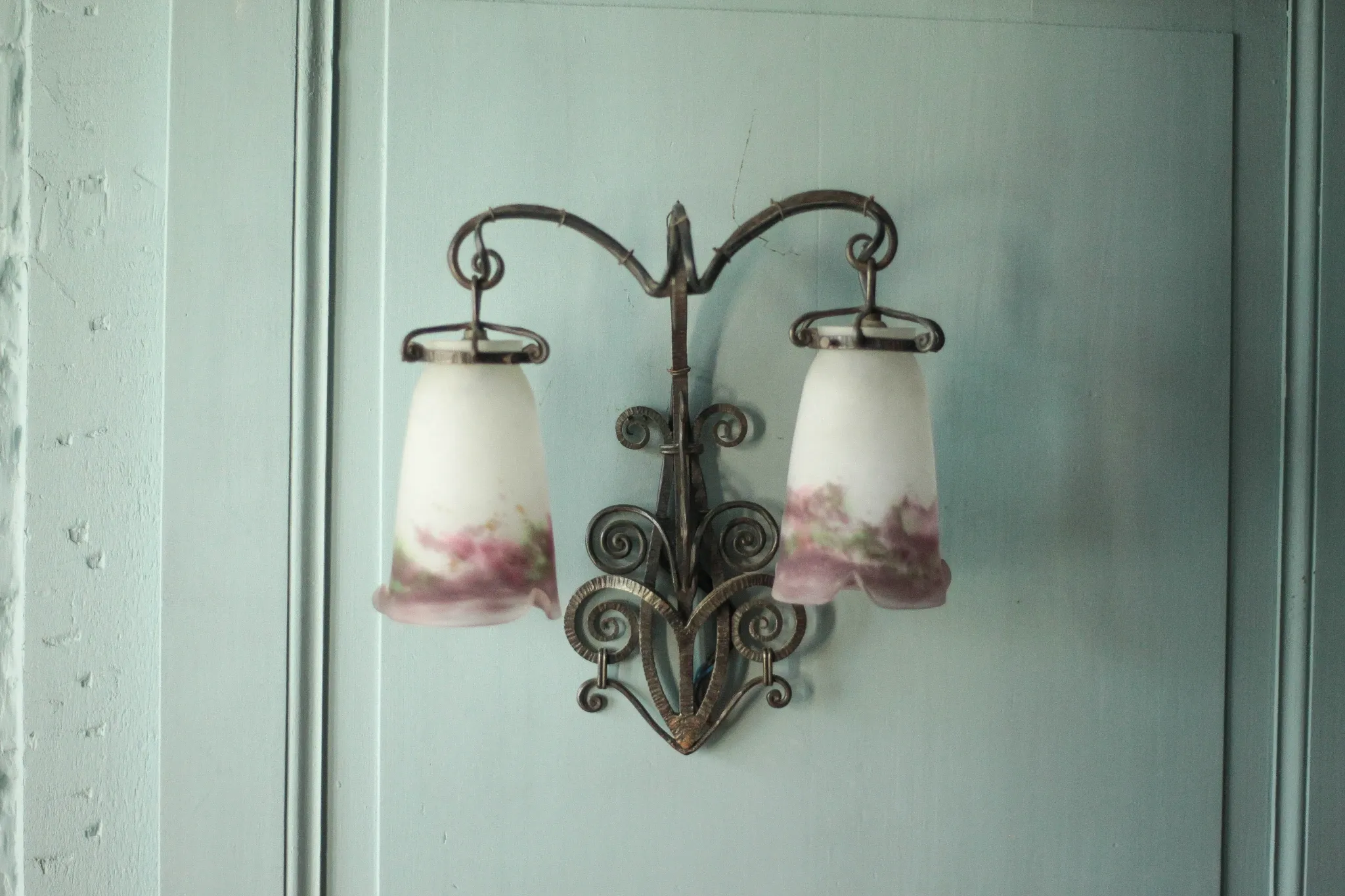 Wall lamp in wrought iron with a pink tulip glass globe by Muller glassworks.