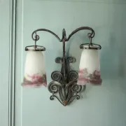 Wall lamp in wrought iron with a pink tulip glass globe by Muller glassworks.