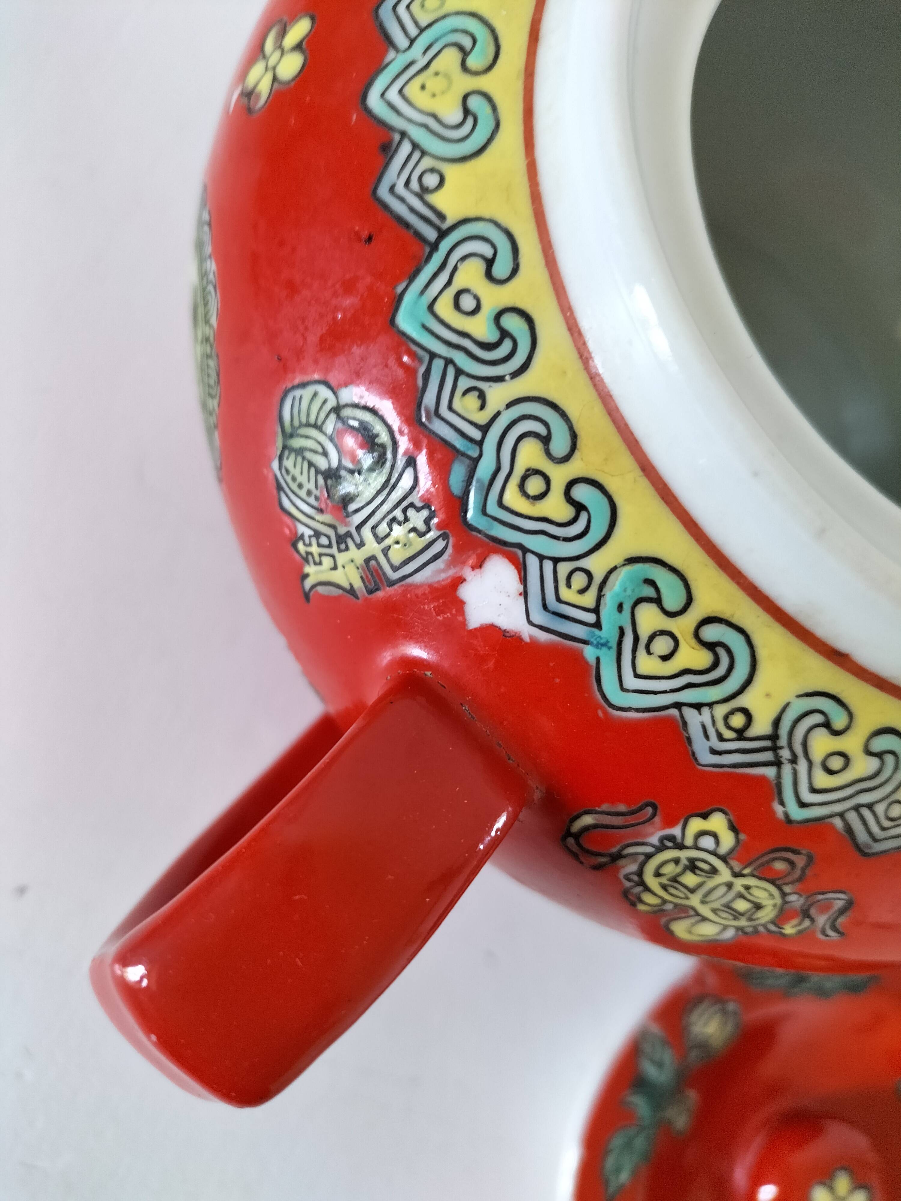 Vintage red Chinese teapot decorated with dragons and symbols.