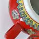 Vintage red Chinese teapot decorated with dragons and symbols.