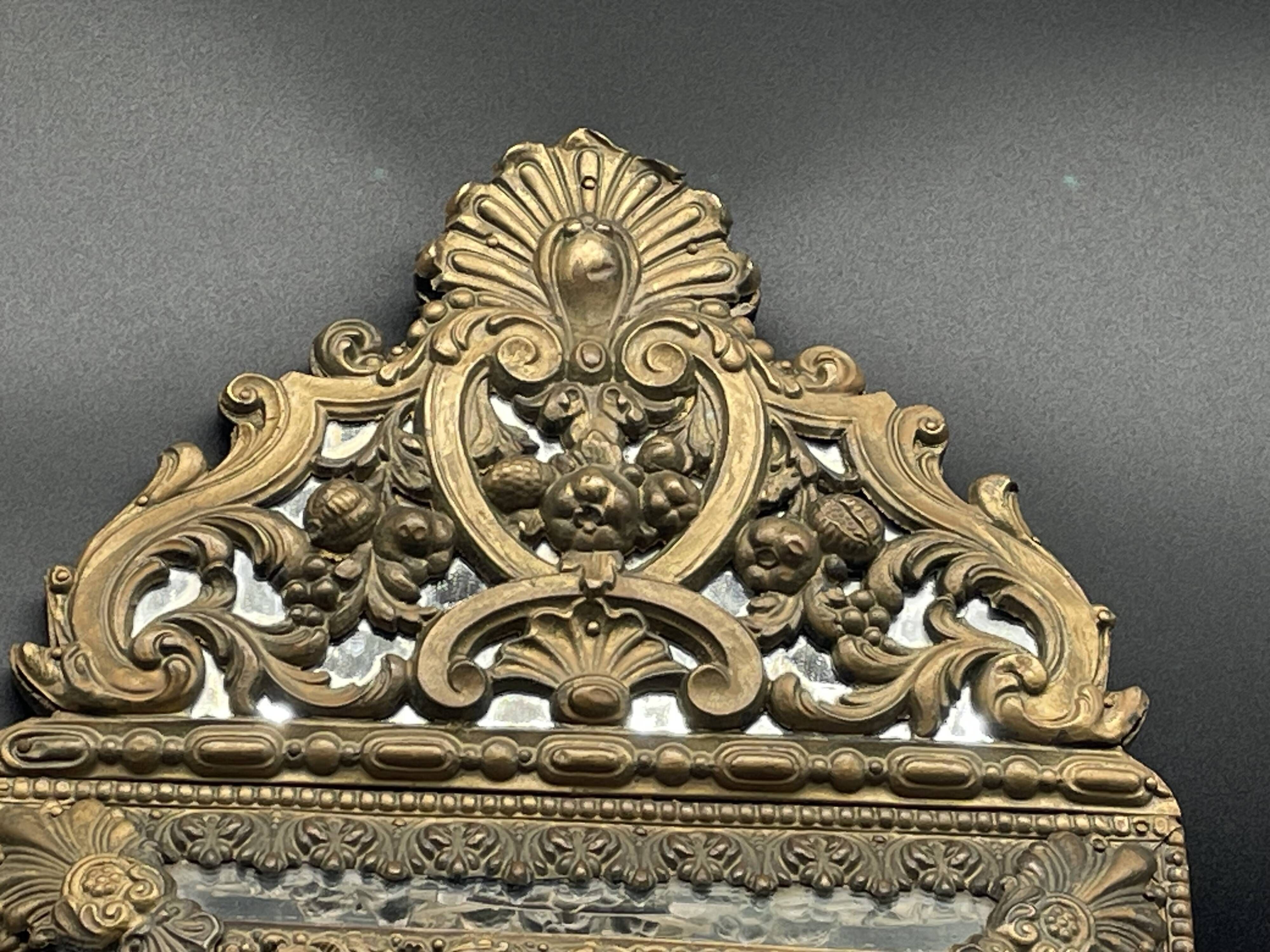 Small mirror with brass parcloses in repoussé style Louis XIV, late 19th century.