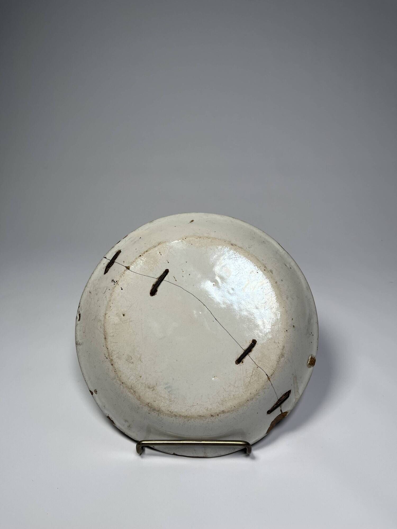 Two antique 18th-century faience plates, stapled.