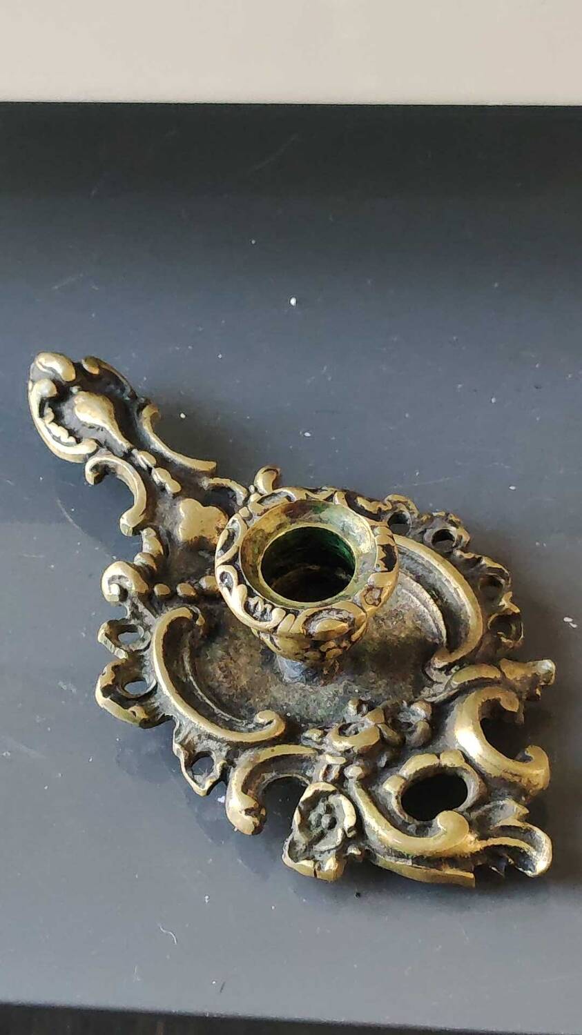 Antique Baroque/Rocaille style hand candle holder. In bronze with an old gold patina.