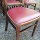 Set of 19 vintage wooden bistro chairs with red faux leather.