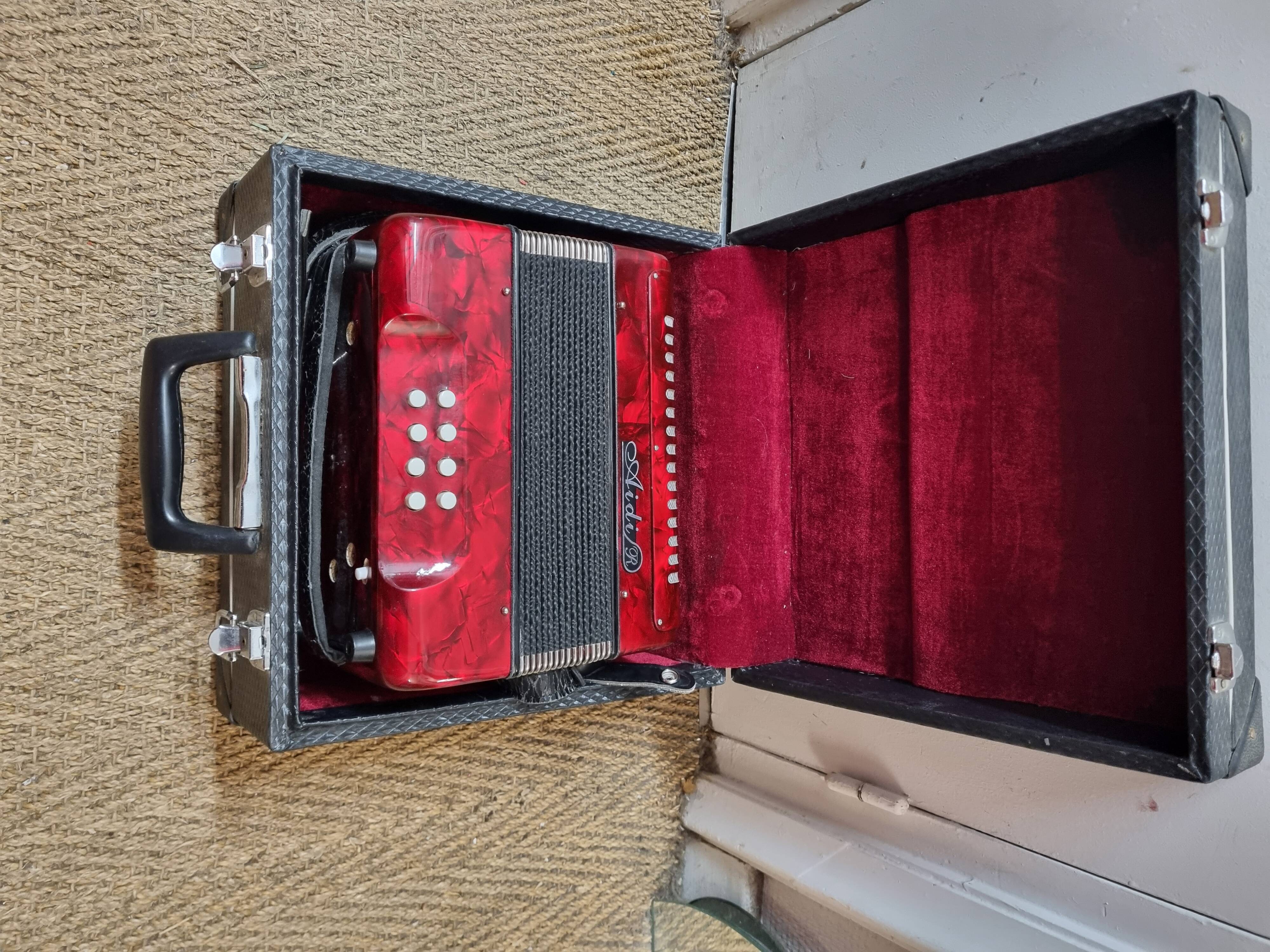 Red Aidi R accordion in his suitcase