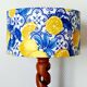 Turned wooden lamp with a lampshade featuring lemon tiles.