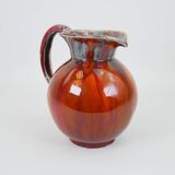 Large red and blue glazed ceramic pitcher signed Delène under the base