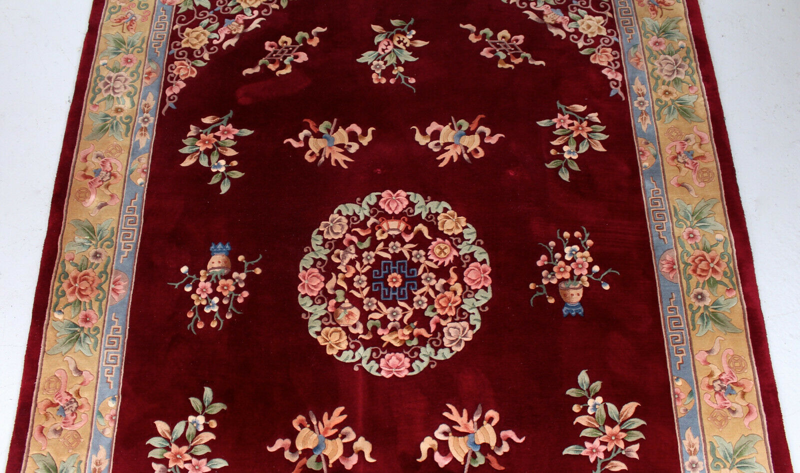 China wool fringed rug with floral pattern on deep plum background 393x274cm
