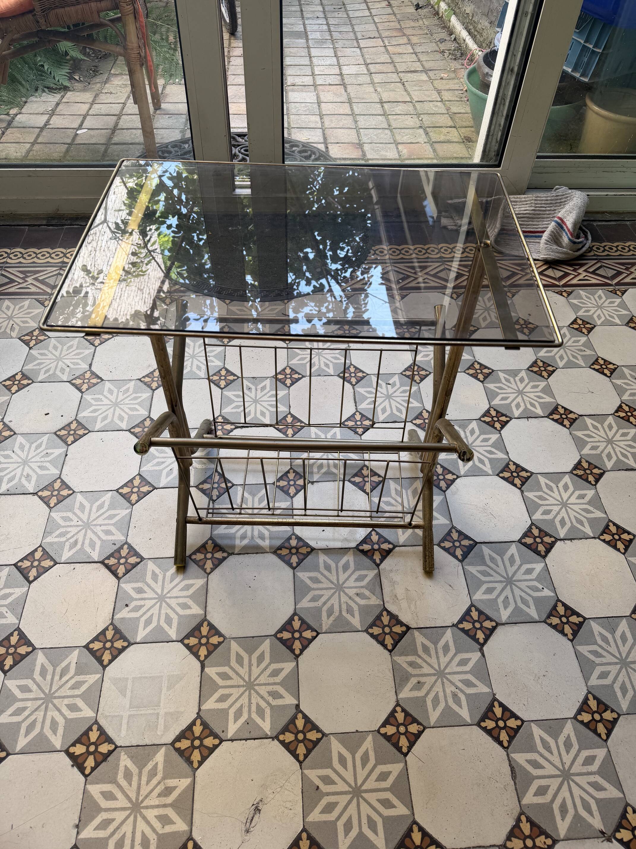 Vintage style side table with magazine holder, gold metal and glass top.