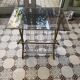 Vintage style side table with magazine holder, gold metal and glass top.