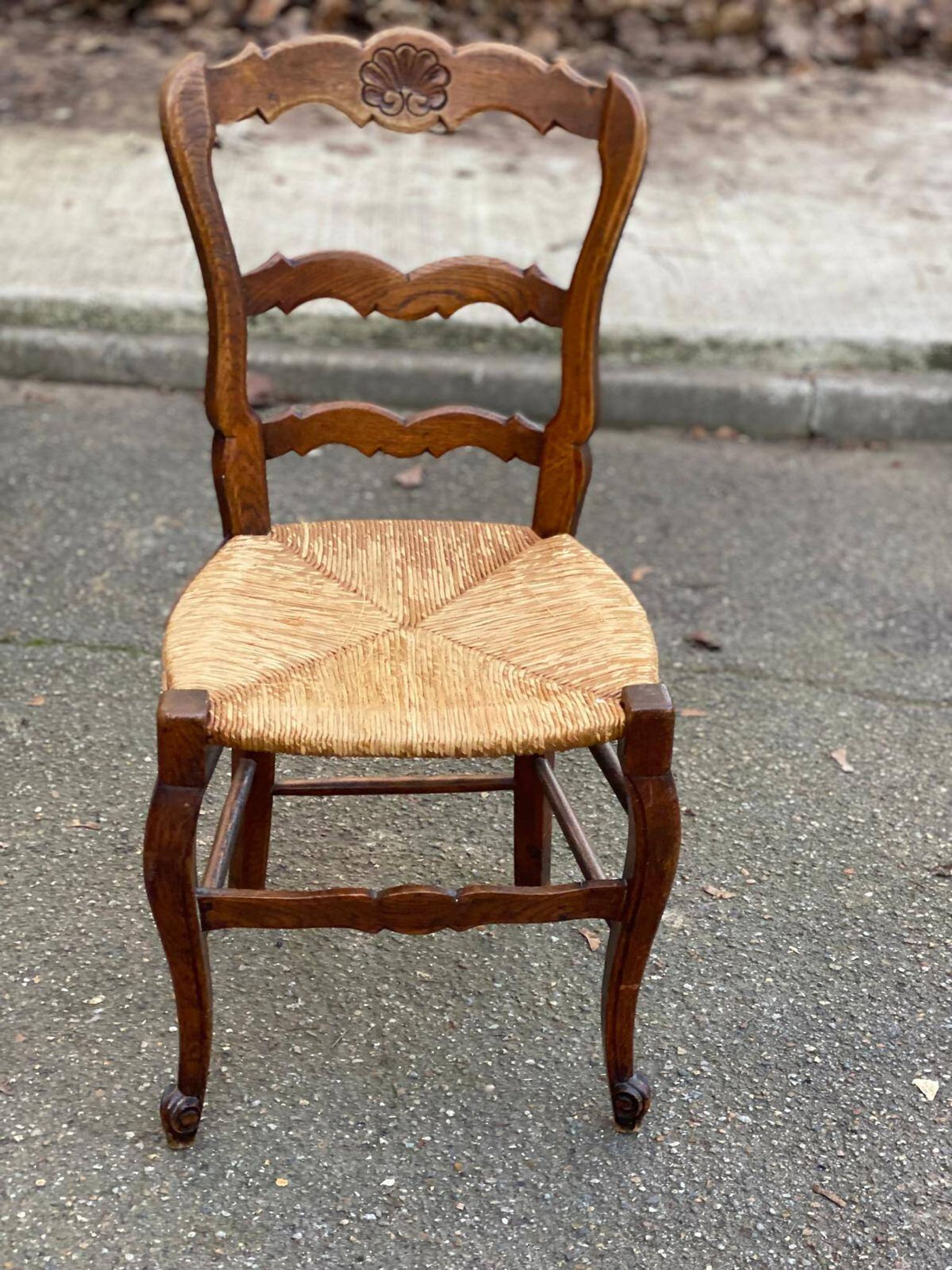 Louis XV 18th century solid wood dining chair with a straw seat.