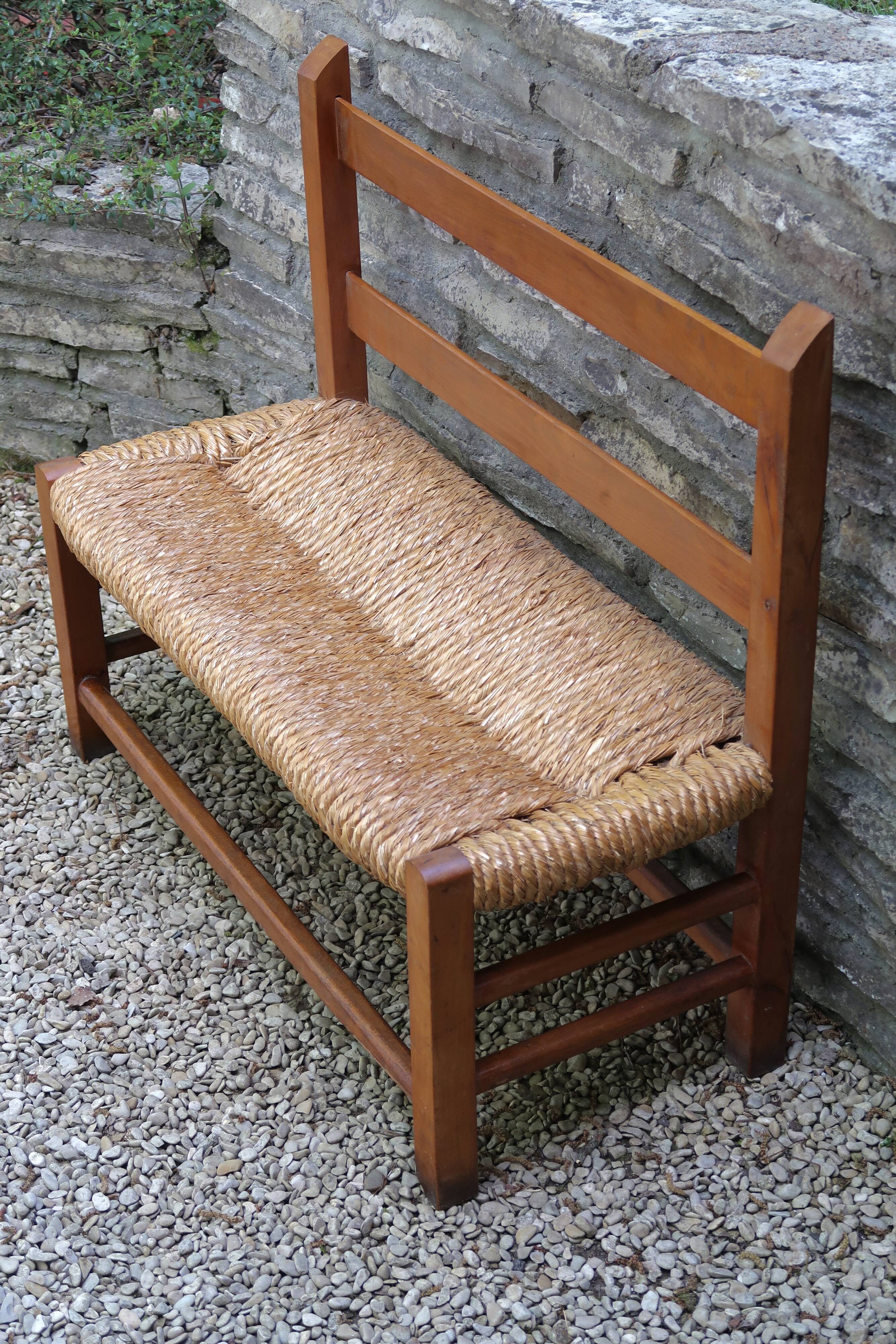 Wooden-backed bench with straw seat, 1970s.
