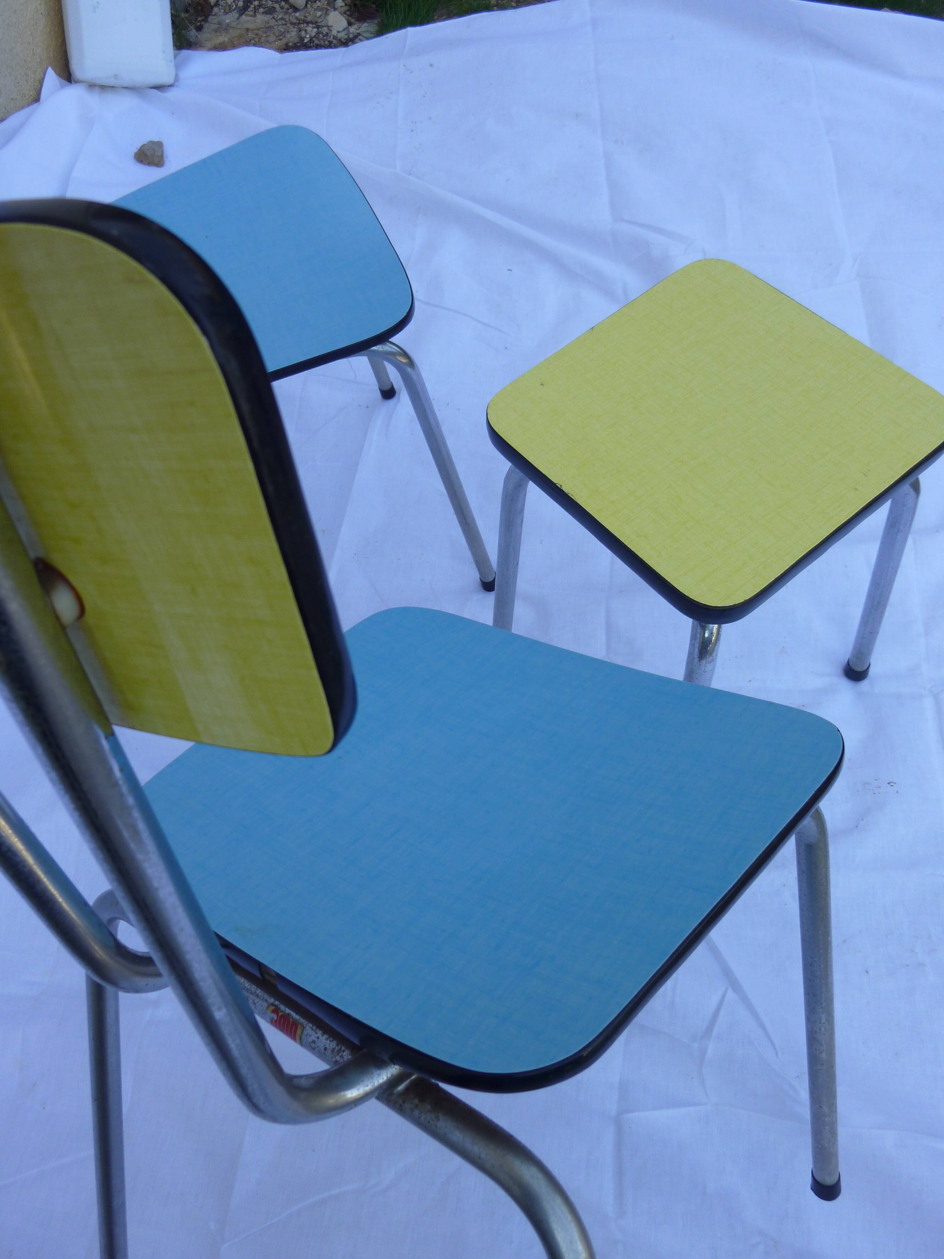 Two chairs and a yellow and blue stool in formica