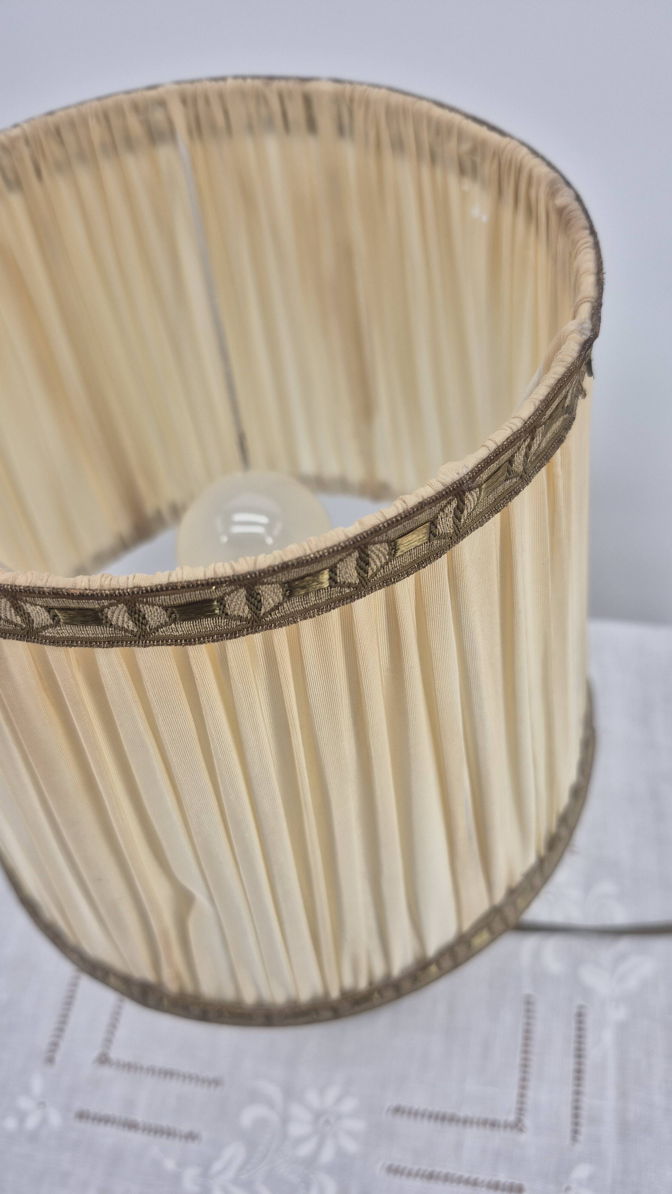 Brass table lamp with green patina and empire-style fabric shade.