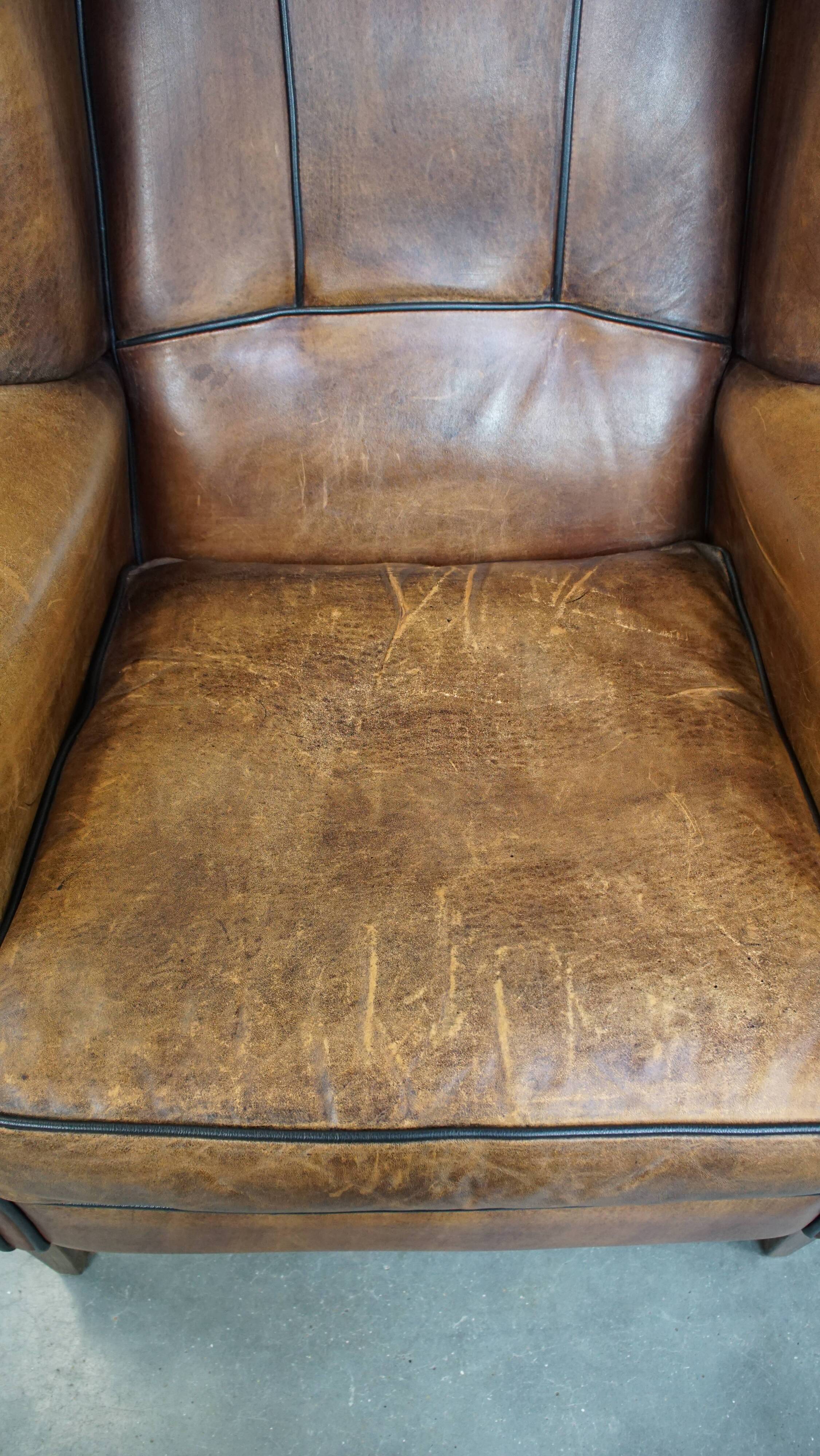 Sheep leather wingback chair finished with black piping