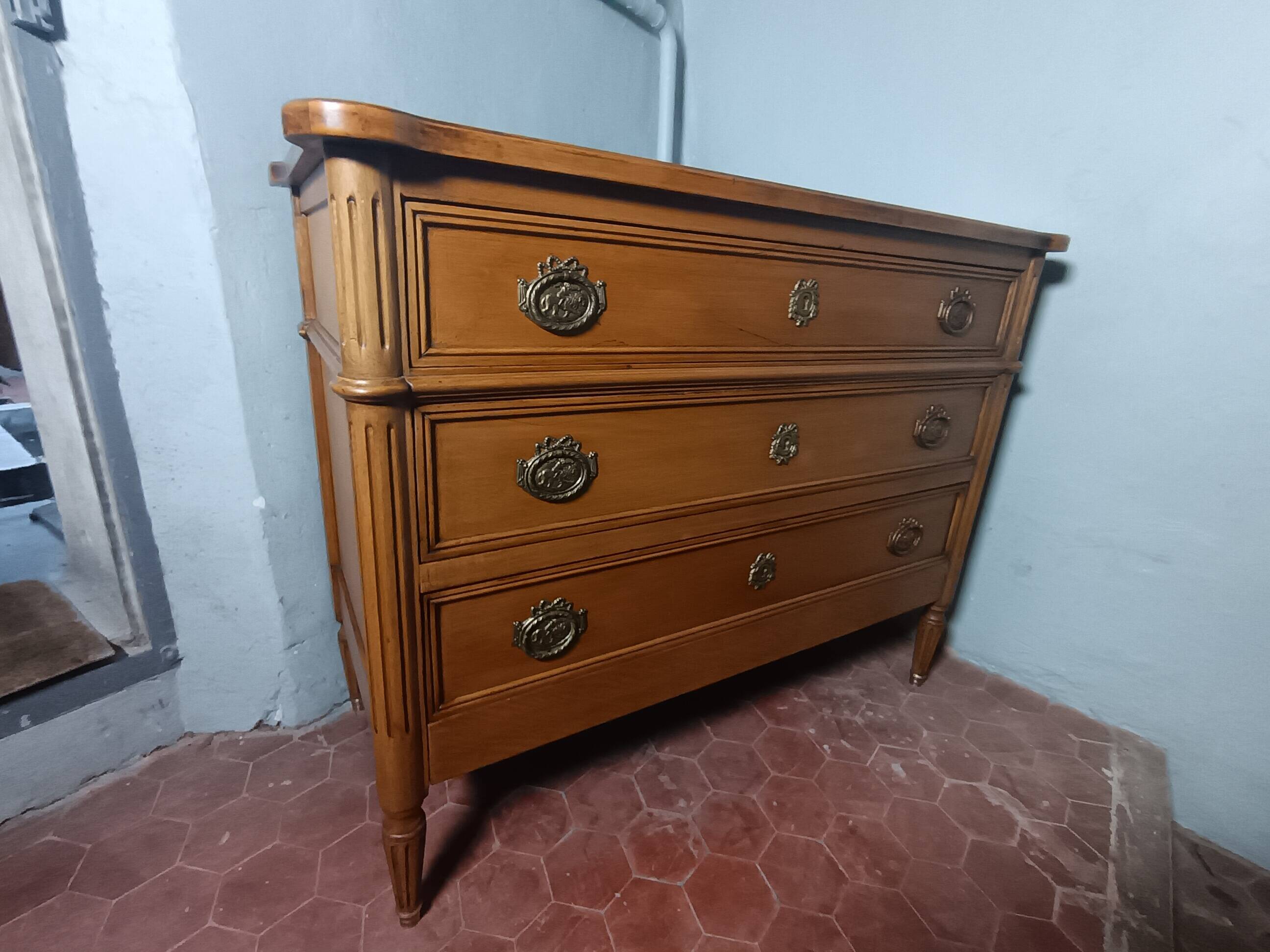 Commode de style Louis XVI ouvrant à trois tiroirs.