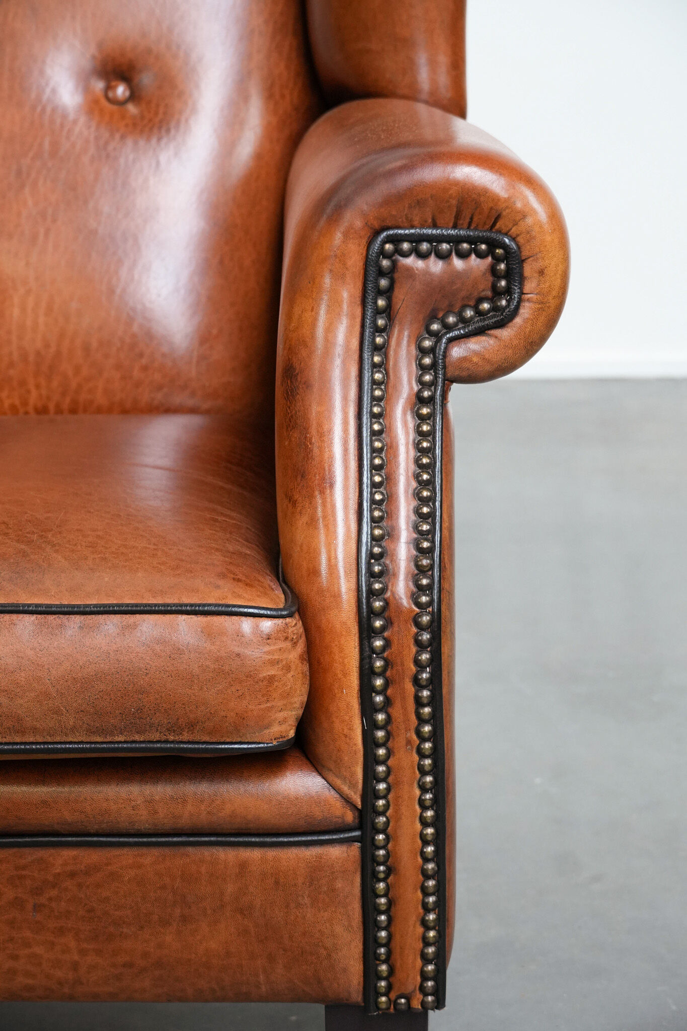 Wingback chair made of sheep leather with black piping in good condition