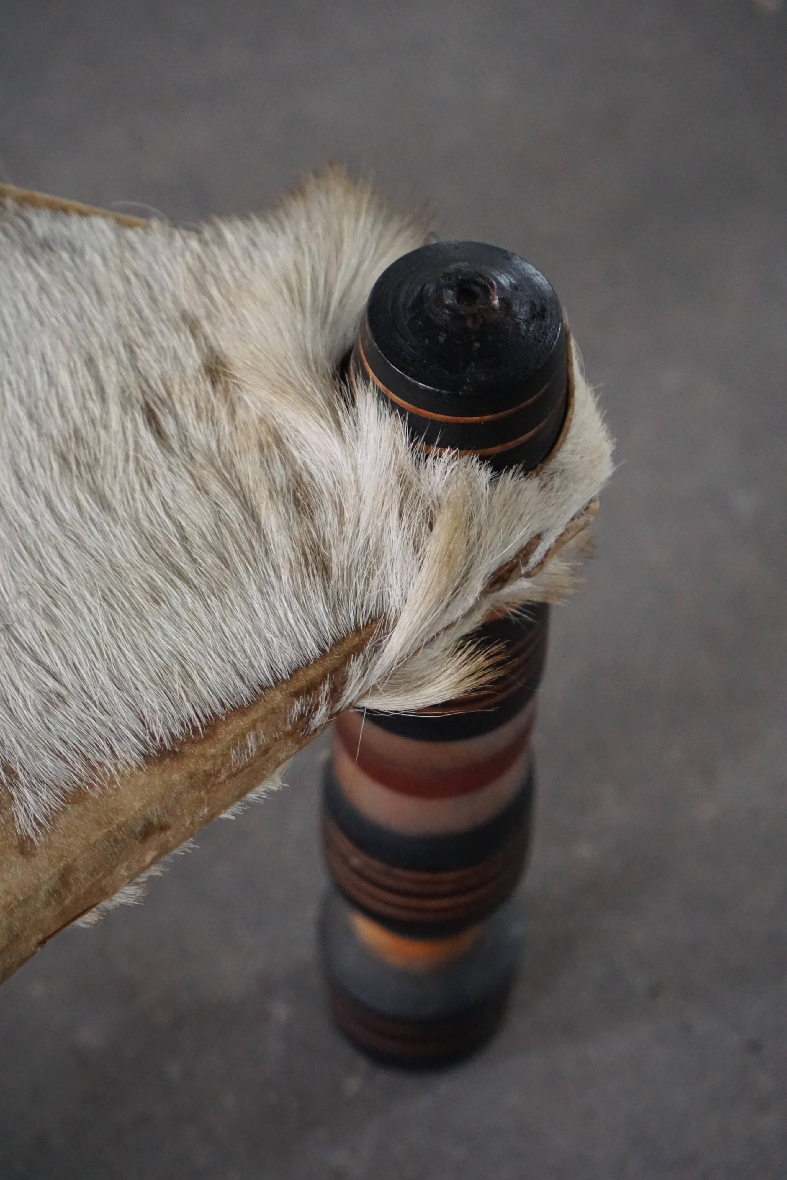 Vintage African artisanal stool, triangular shape with 3 legs, cowhide, 20th century.