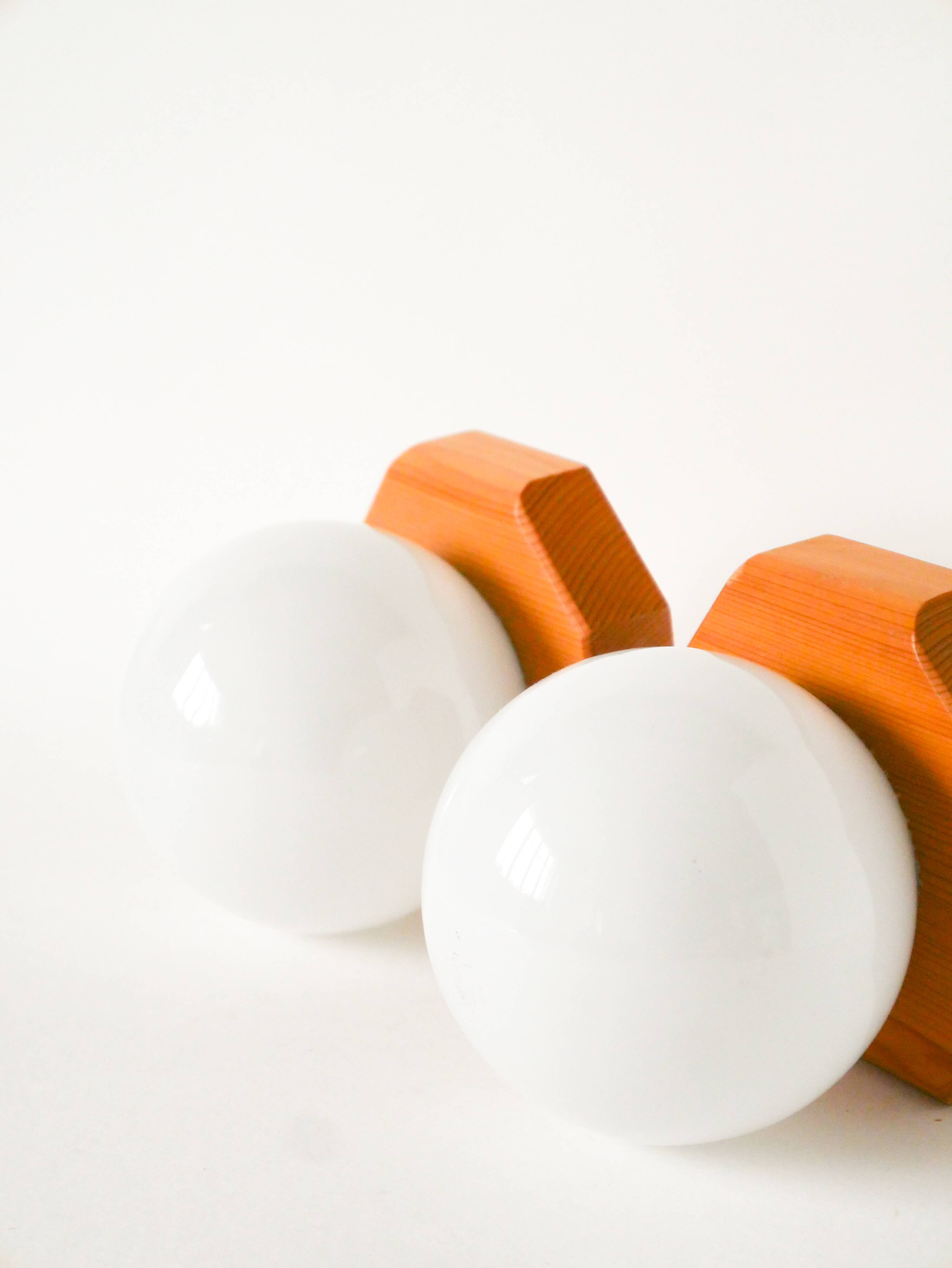 Pair of globe wall lights in opaline with a pine base, 1980.