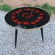 Vintage coffee table with glass top and tripod legs in blackened wood from the 1960s.
