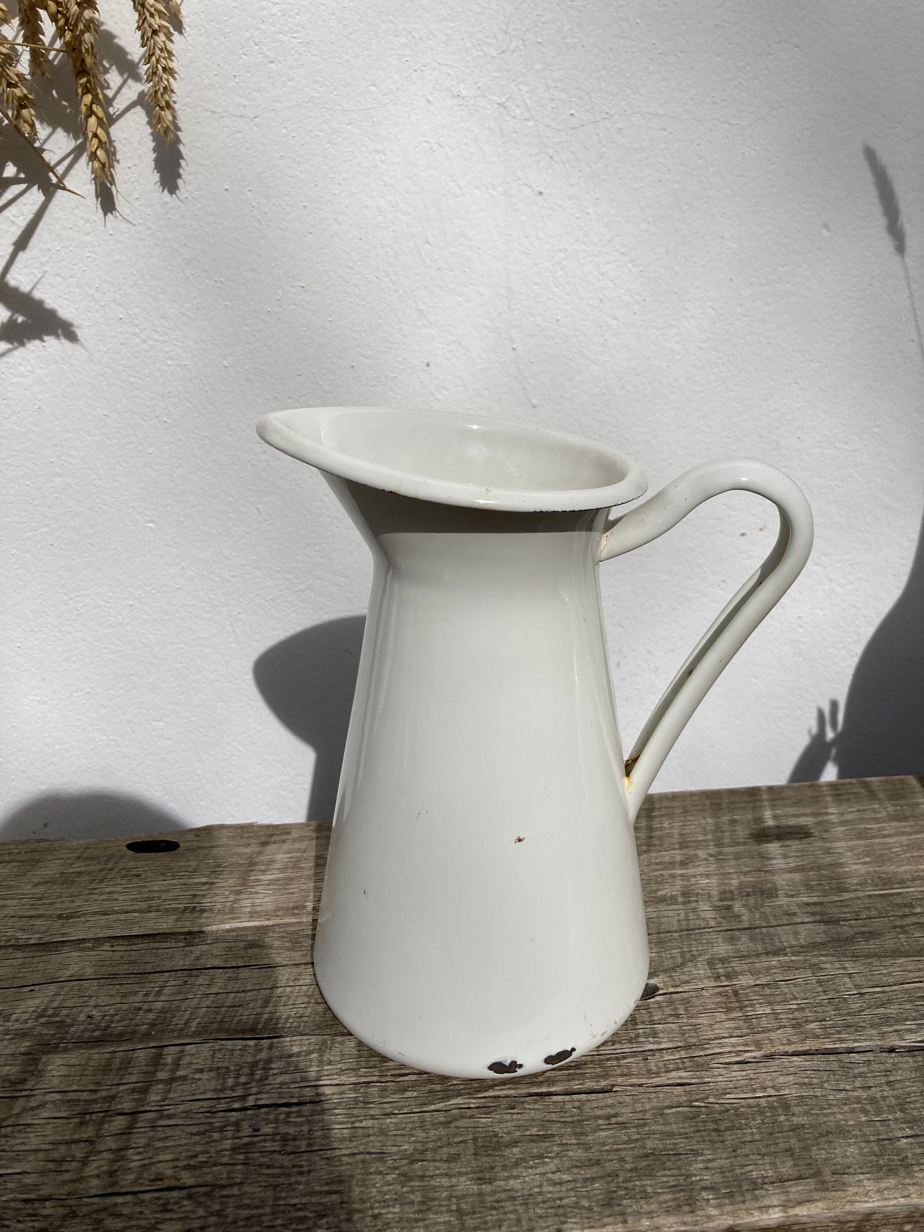 Old white enamelled metal pitcher