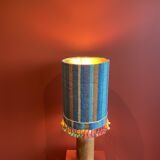 "Stoneware Bottle Lamp" with a multicoloured blue lampshade handwoven in India.