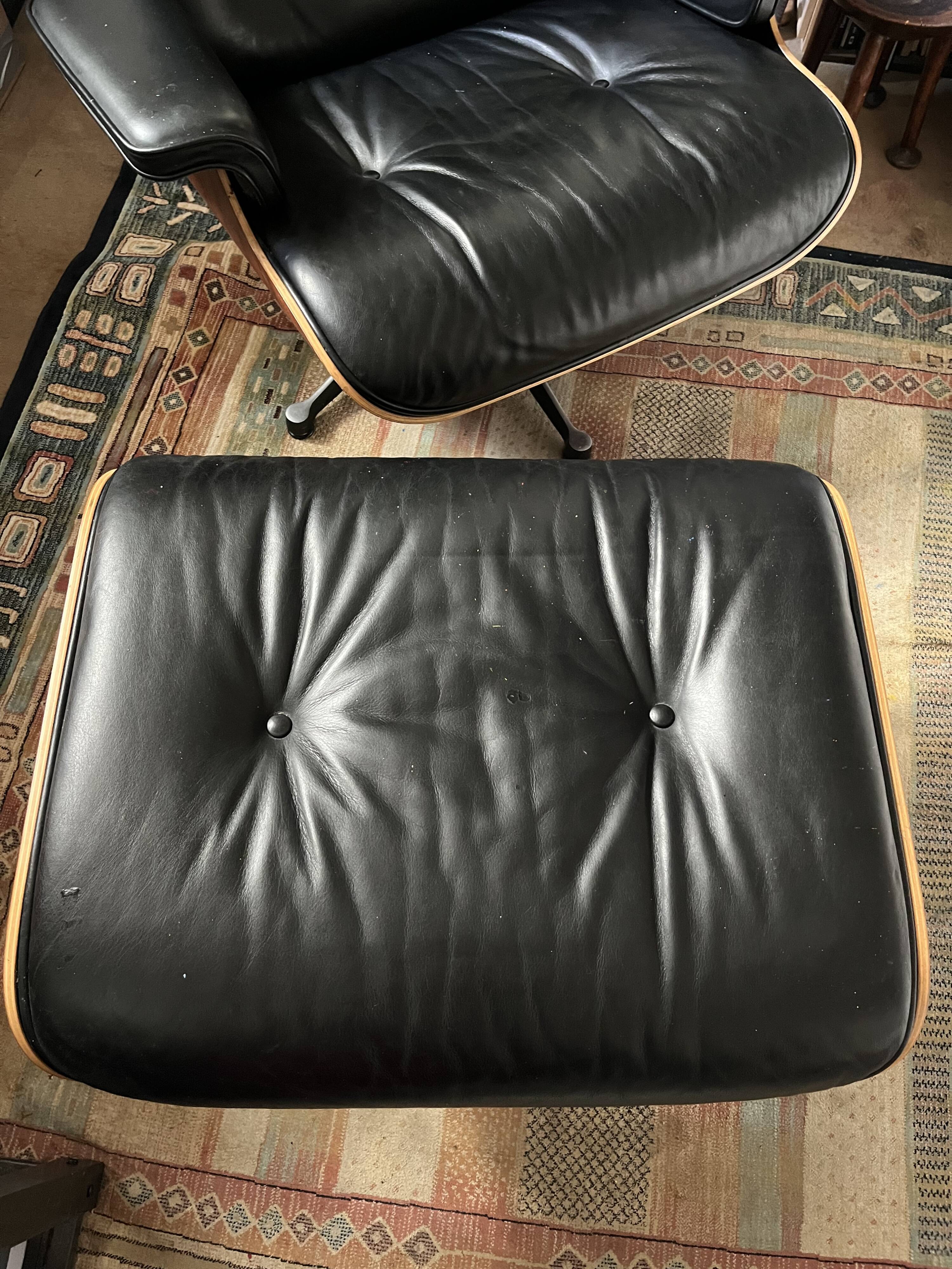 Black leather Eames Vitra armchair, original with rosewood ottoman.